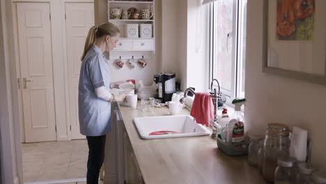 woman doing dishes in kitchen