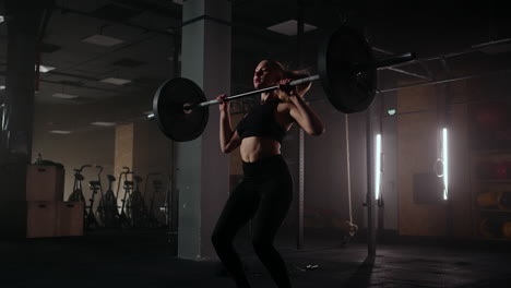 athletic beautiful woman does overhead deadlift with a barbell in the gym. strong female athlete with muscular body lifting weights exercising with barbell. women doing exercise with weights in gym