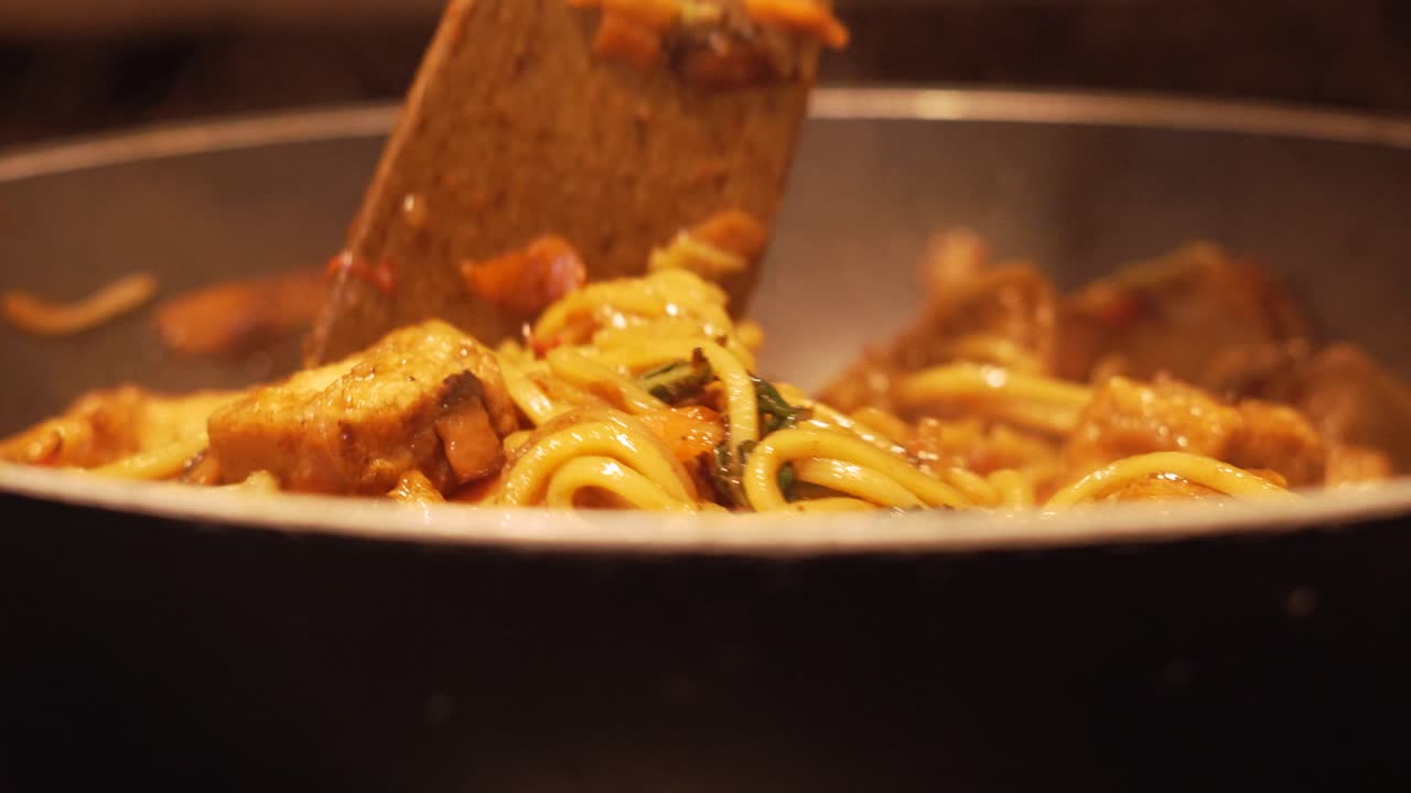 Slow Motion Close Up of Tofu Vegetable Egg Noodles Stir Fry Cooking in Hot Gas Wok