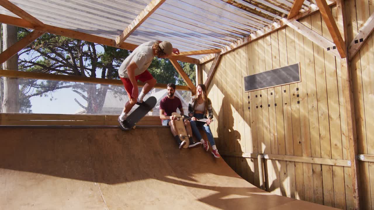 video de felices y diversas patinadoras y patinadores entrenando en un parque de patinaje