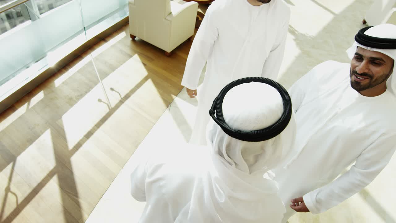 emirati hombres colegas de negocios saludo de apretón de mano oficina del centro