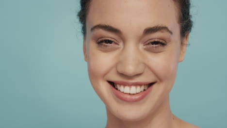 close-up-portrait-gorgeous-young-woman-smiling-with-beautiful-healthy-skin-complexion-looking-confident-sensual-beauty-on-blue-background-skincare-concept