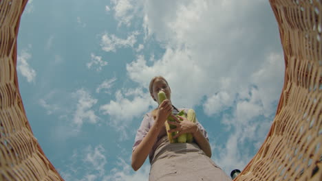 young woman picking corn from a basket