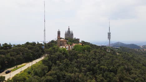 Aerial-drone-4K-footage-of-Tibidabo-in-Barcelona,-showcasing-the-majestic-mountain,-iconic-amusement-park,-and-panoramic-views