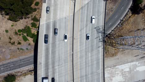 birds eye view drone shot cars driving on freeway overpass in california