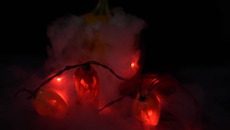 pepper jack o lanterns and a pumpkin with dry ice fog coming out dark photography