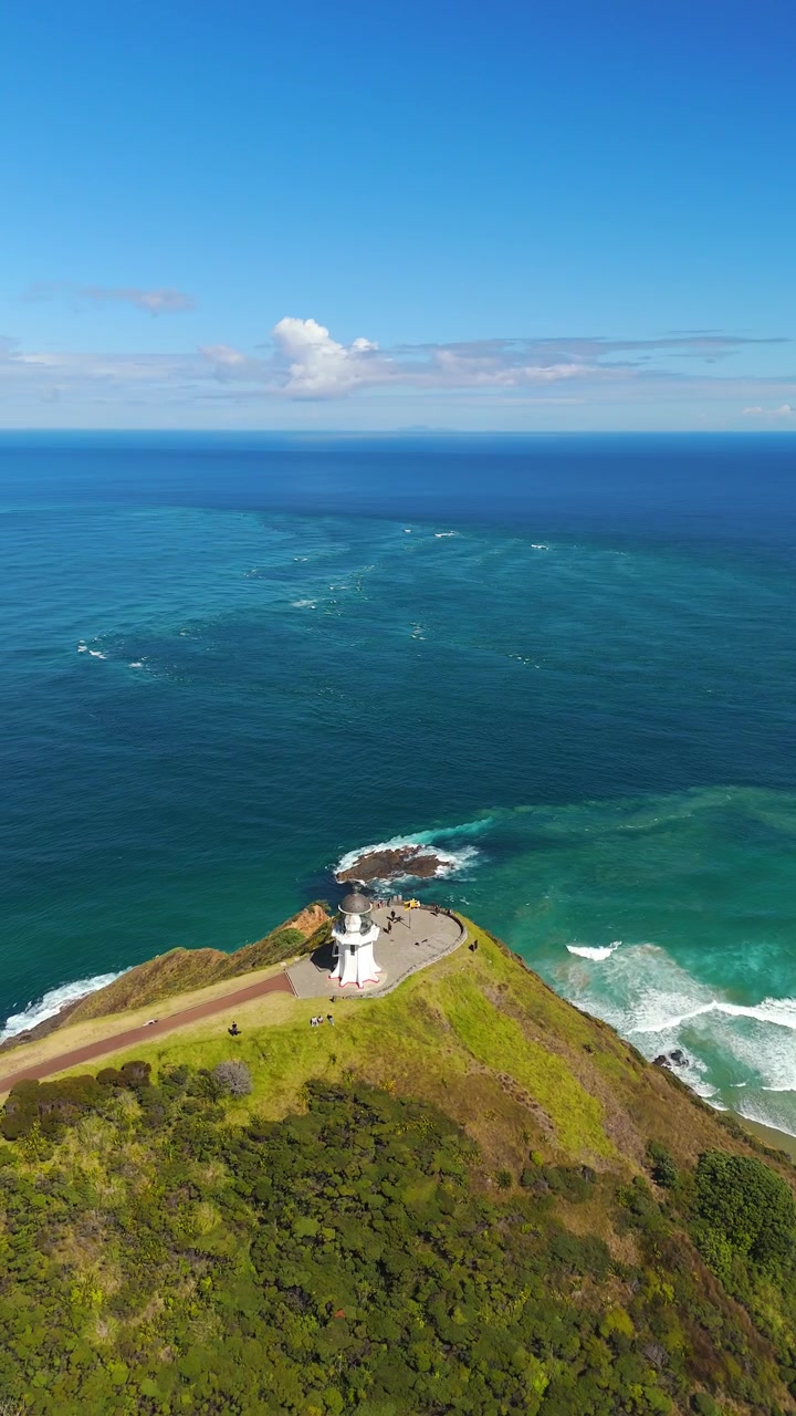 Faro di Cape Reinga sopra una costa frastagliata e l'oceano. Vista aerea