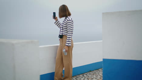 turista haciendo fotos de vacaciones en la orilla del mar. hermoso blogger creando contenido