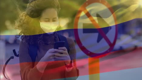 Bandera-Colombiana-Ondeando-Contra-Una-Mujer-Que-Usa-Mascarilla-Usando-Un-Teléfono-Inteligente