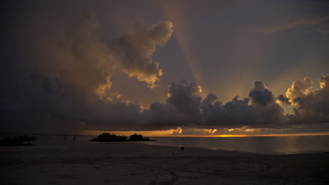 Toma-Panorámica-Lenta-De-Una-Fascinante-Puesta-De-Sol-Con-Rayos-De-Luz-Que-Salen-De-Las-Nubes-En-Un-Cielo-Celestial-En-Una-Playa-De-Cancún,-México.