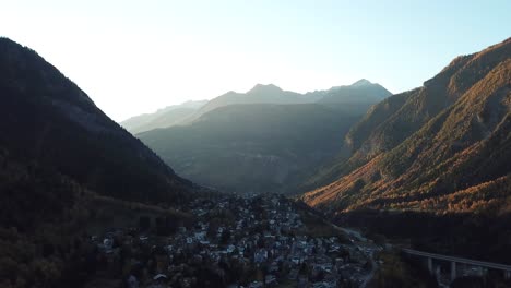 Calm-rotating-aerial-over-Courmayeur,-Italy,-Aosta-Valley,-Italian-Alps-in-autumn-with-fall-colors-on-forest-with-golden-trees-on-mountain-side