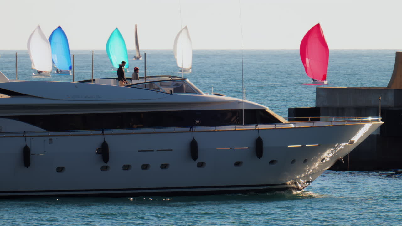 Nizza, Francia - 10 febbraio 2025: una barca con la bandiera di Monaco che si muove sul mare con piccole barche a vela sullo sfondo