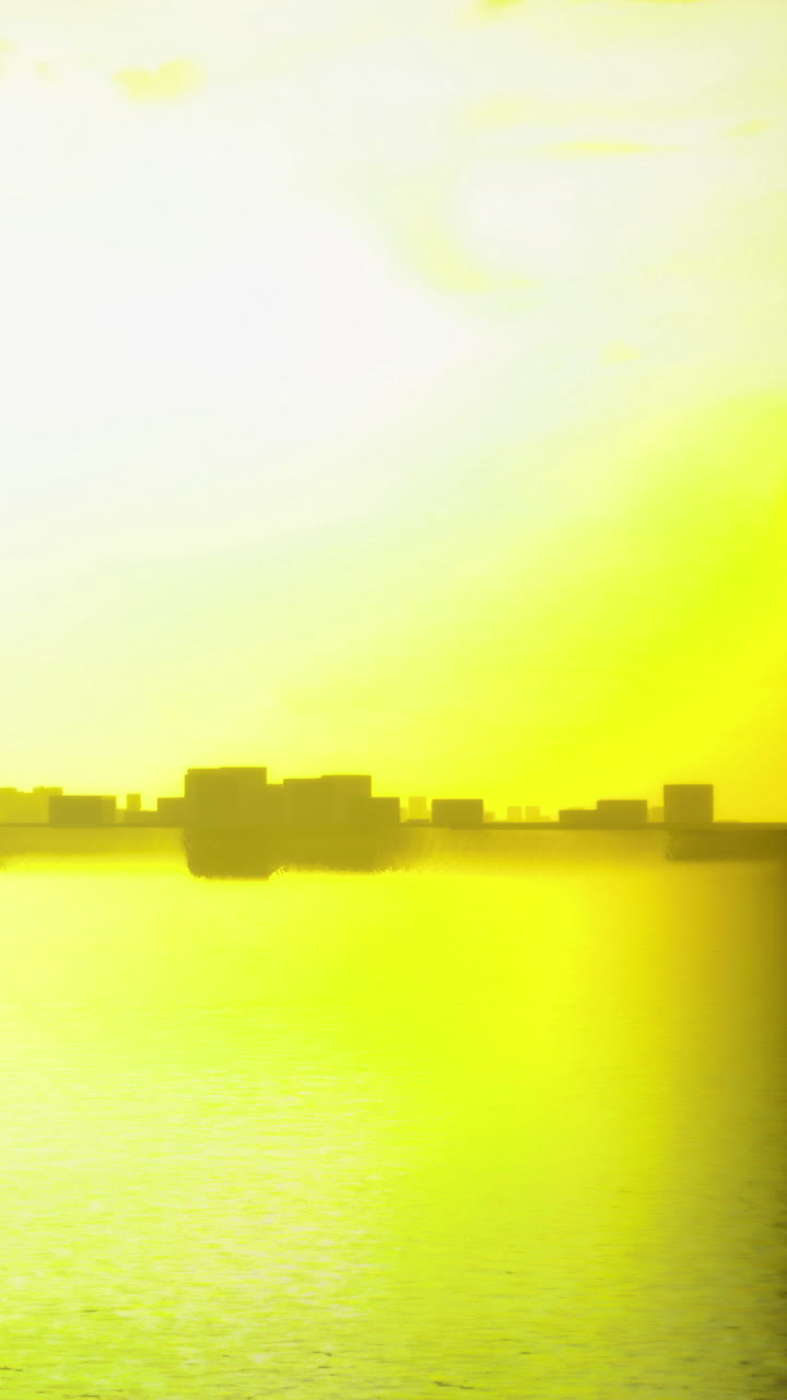 Luz solar brillante se refleja en agua tranquila cerca del horizonte de la ciudad durante la tarde.