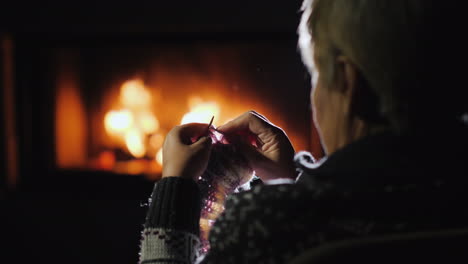 Woman-Handicrafts-By-The-Fireplace-Knits-Warm-Clothes