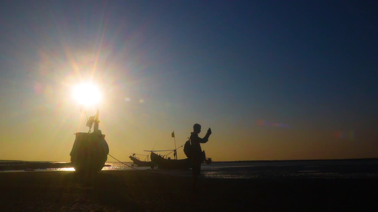 Tourist posing and photographer capturing photo on the coast of Saint Martin Island. Traditional boats with burning sun in the background, timelapse