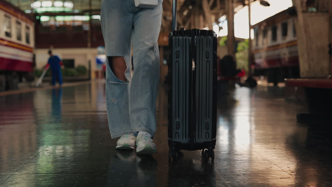 Woman walking with luggage at train station
