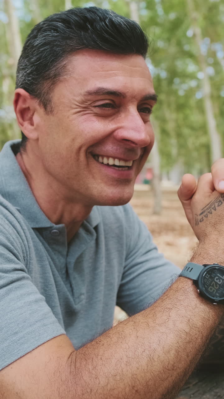 Uomo felice che parla e sorride all'aperto in un parco