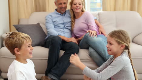 Happy-siblings-playing-a-game-on-rug