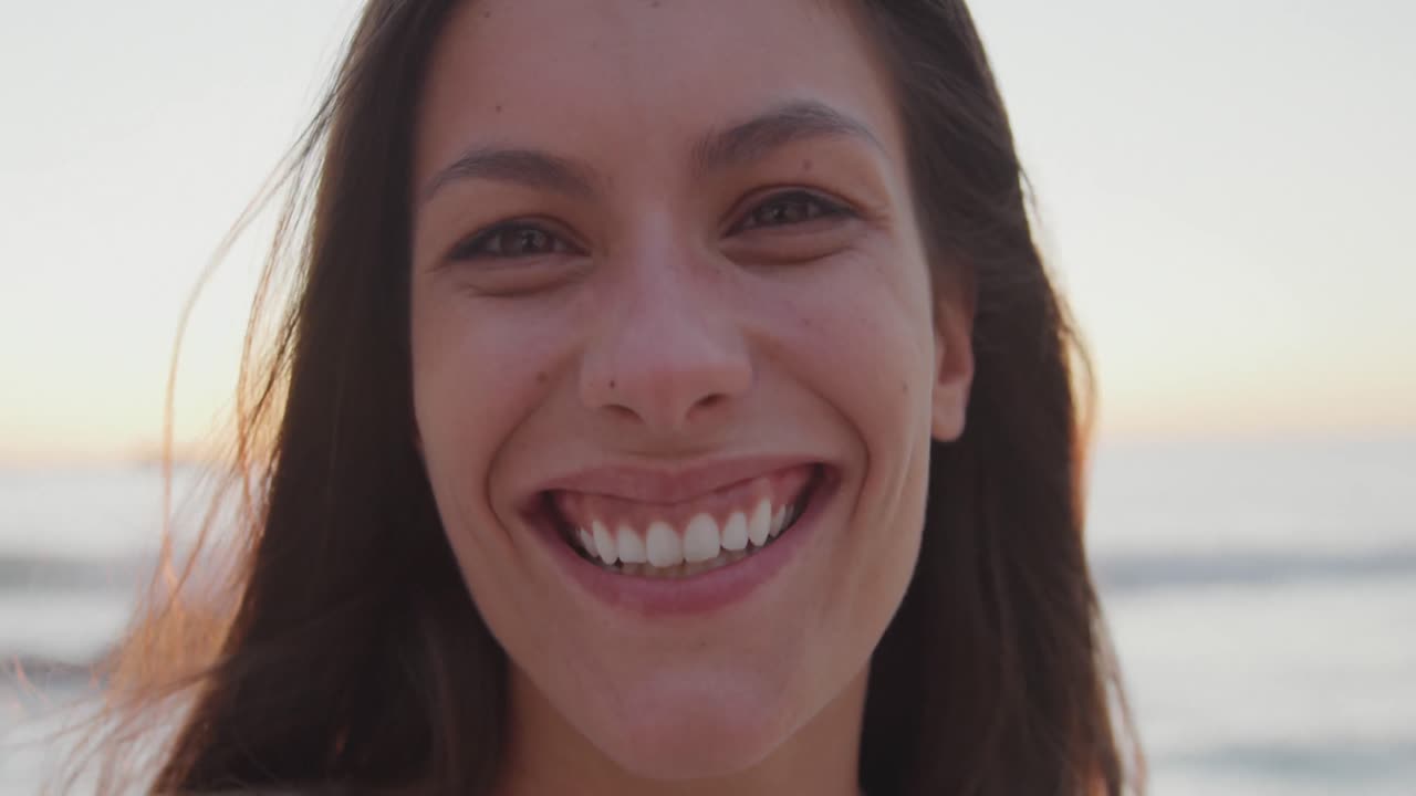 retrato de una mujer joven sonriendo en la orilla del mar