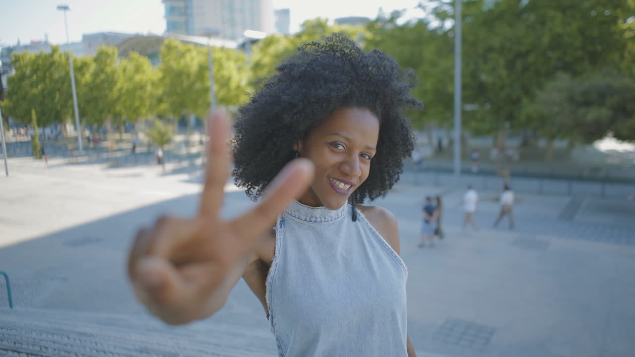 Cheerful woman chewing gum, showing thumbs up, victory gestures