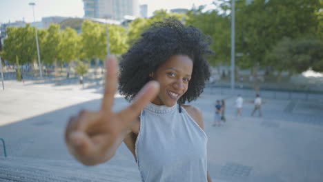 cheerful woman chewing gum, showing thumbs up, victory gestures