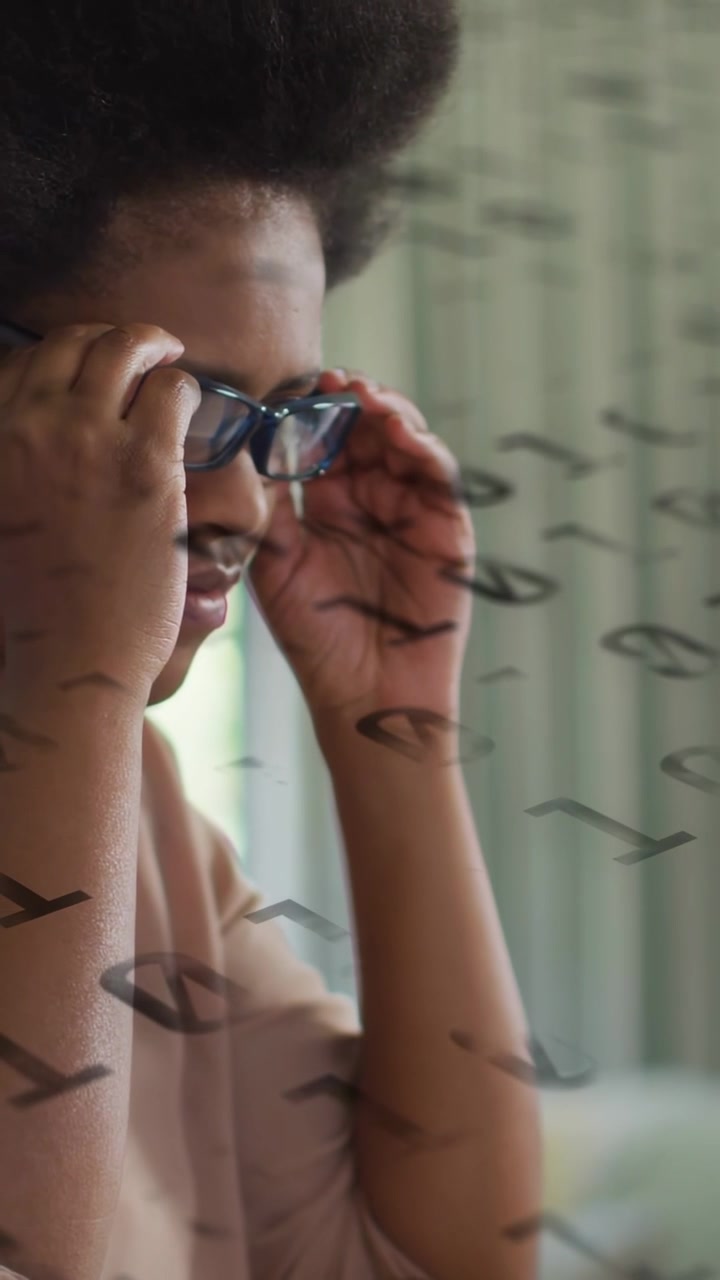 Vertical video: Woman leaning toward laptop adjusting blue frames, tech overlay helping focus