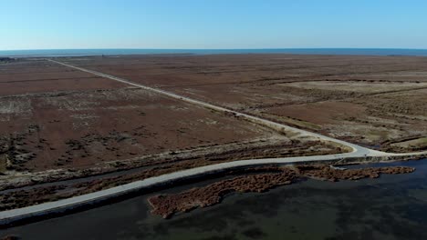 low lying coastline of beautiful seaside with shallow lagoon and below sea level land with dry brown grass