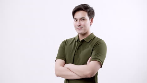 a confident young man in an olive-green polo shirt stands with arms crossed, showing ambition and determination. the white background emphasizes his professional and business-oriented attitude.