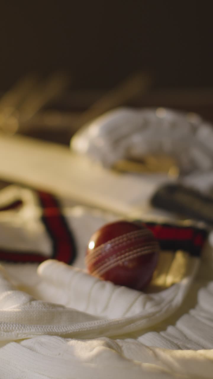 Cricket-Stillleben mit Nahaufnahme von Schläger, Ball, Handschuhen, Stumps, Pullover und Bails, die auf einer Holzoberfläche im Umkleideraum 3 liegen