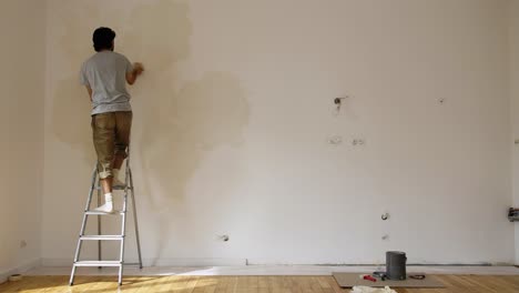 Hombre-En-La-Escalera-Dentro-De-La-Habitación-Vacía-Pintura-Con-Cal