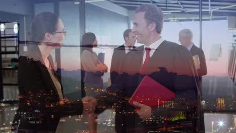 caucasian businessman and businesswoman shaking hands at office over aerial view of night cityscape