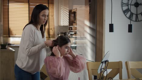 Caucasian-woman-doing-hairstyle-for-her-daughter-for-prom