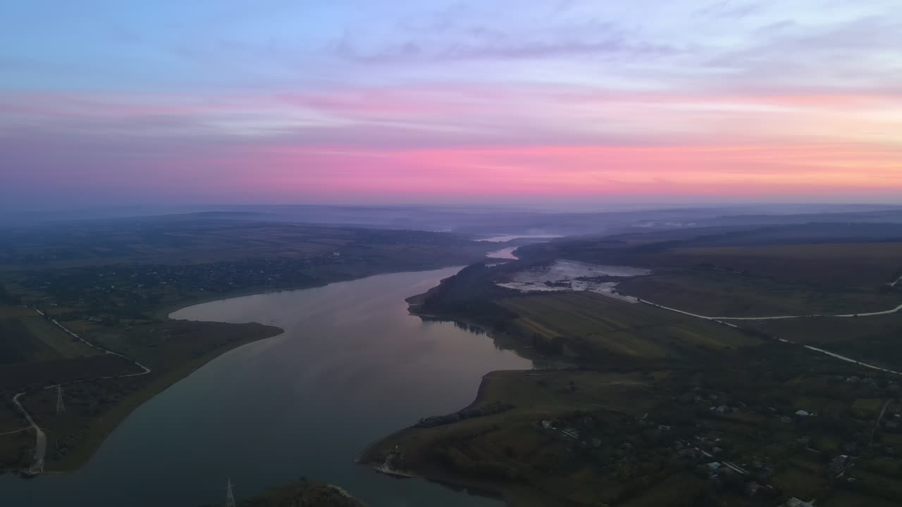Aerial drone view of the Duruitoarea natural reservation at sunset in Moldova. River and village, hills and fields