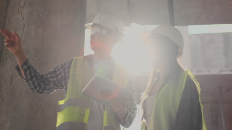 construction worker and engineer talking at construction site site. workers in helmets at building area. portrait of construction engineers working on building site. concept of modern construction