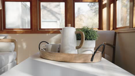 hot water kettle and a plant inside of a tray in the sunroom of a home