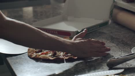 cook preparing pizza for delivery on kitchen