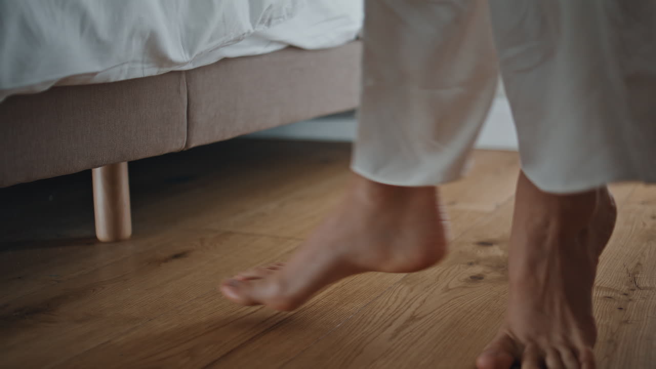 Closeup woman walking toes in morning. Girl waking up get out cozy bed at home