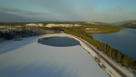 snow covered lake, road surrounded by a lake on both sides, aerial