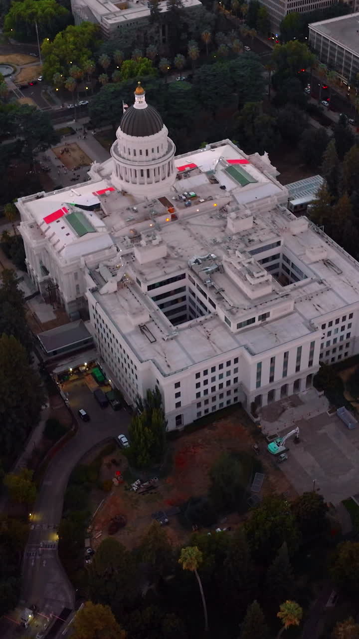 Stunning building of California State Capitol in Sacramento, USA. Aerial view of the establishment surrounded by beautiful green park. Vertical video