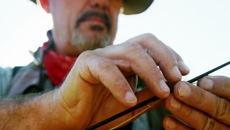 Fly-fisherman-putting-new-string-on-fishing-rod