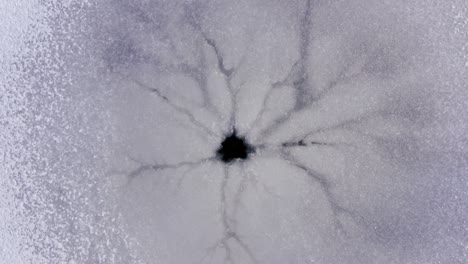 round hole in a frozen lake. a natural hole from an underwater spring