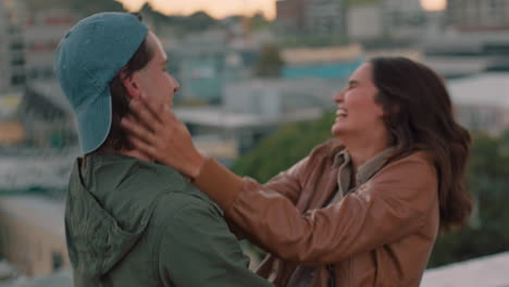 happy caucasian couple hugging on rooftop young woman excited to see boyfriend sharing intimate connection hanging out enjoying romantic view of city at sunset