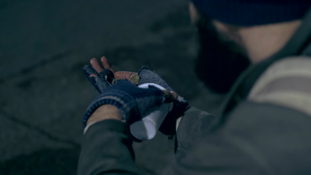 un mendigo contando sus limosnas diarias de cerca