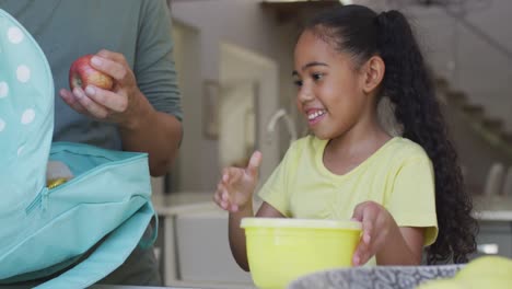 Glücklicher-Gemischtrassiger-Vater-Und-Tochter,-Die-Mittagessen-Für-Die-Schule-Packen