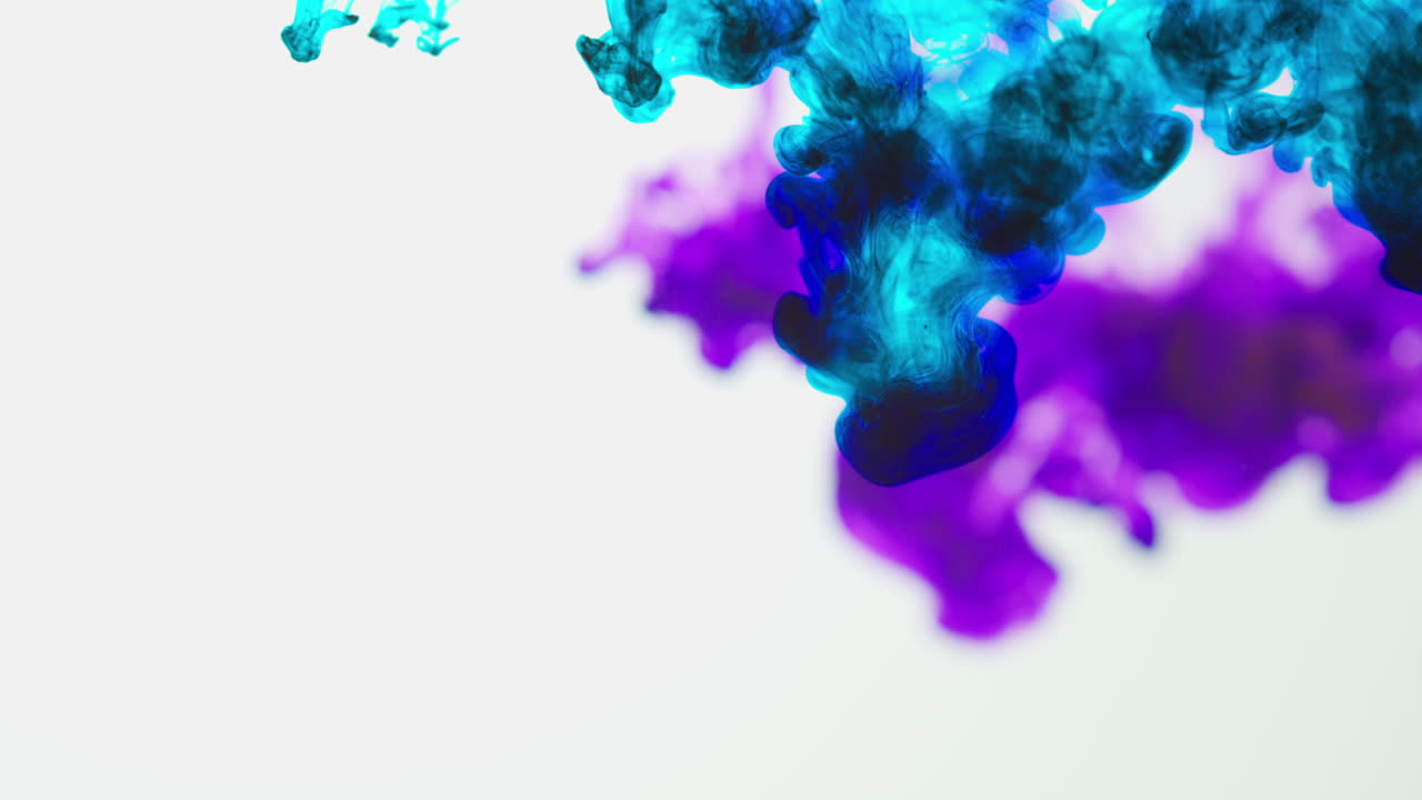 Purple And Blue Paint Or Dye Dropped Into Water Against White Background To Create Swirling Colourful Smoke Background 3