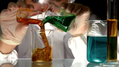 scientist pouring and mixing chemicals in beaker