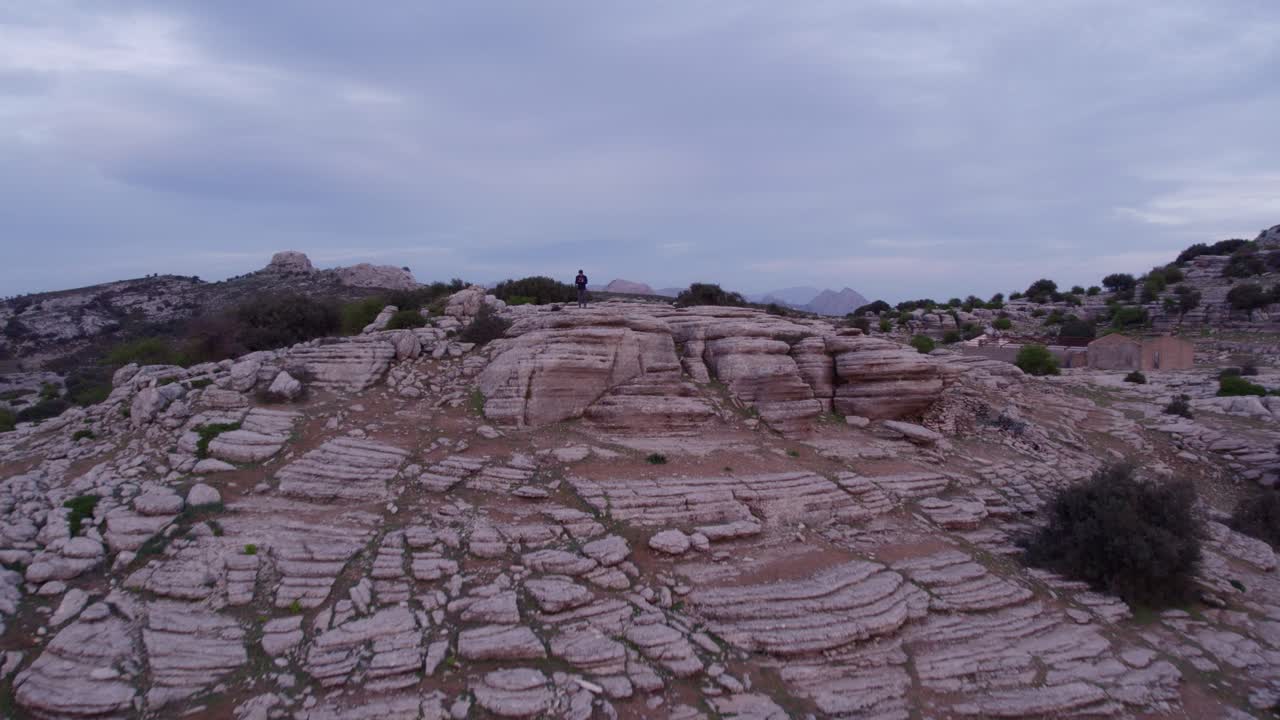 Uomo in piedi tra le rocce di El Torcal al tramonto in Spagna