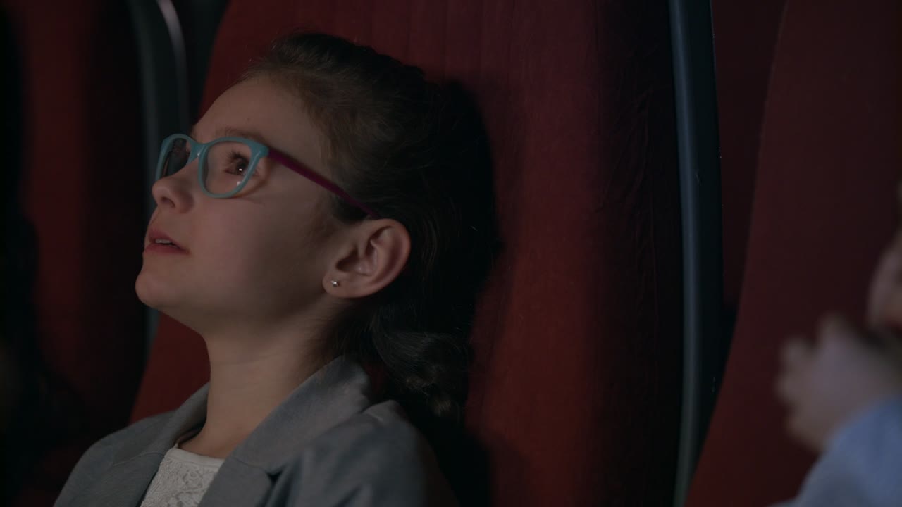 chica enfocada viendo una película de cine. primer plano de niños viendo una película