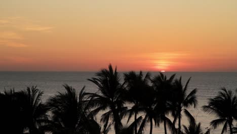 puesta de sol detrás del horizonte en el mar visto desde la playa