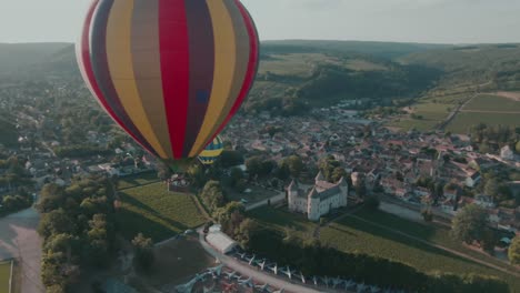 4k aerial two hot air balloons in the air and airfield in background